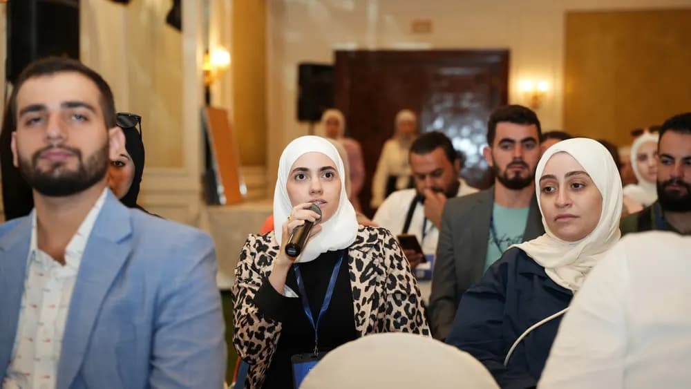 An attendee asks a question from the audience